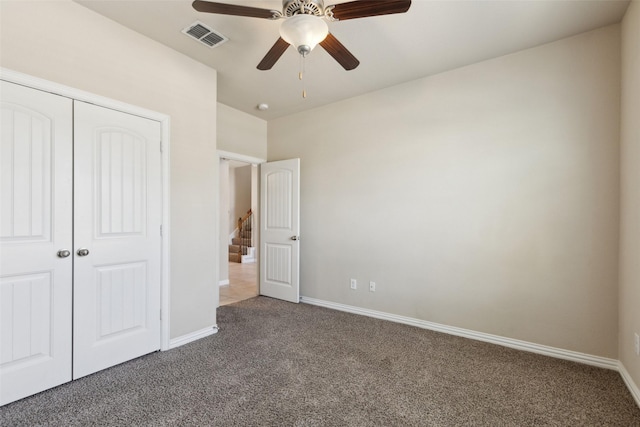 unfurnished bedroom with a closet, ceiling fan, and dark colored carpet