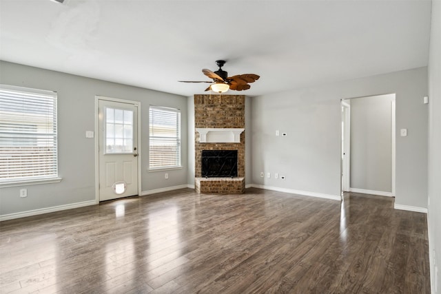 unfurnished living room with dark wood-type flooring, ceiling fan, and a fireplace