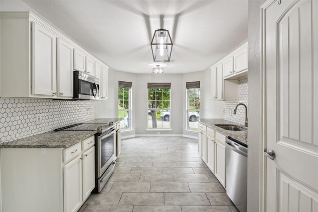 kitchen featuring sink, tasteful backsplash, stone countertops, stainless steel appliances, and white cabinets