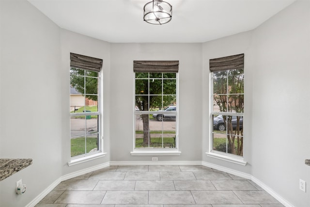 unfurnished dining area featuring light tile patterned flooring and a healthy amount of sunlight