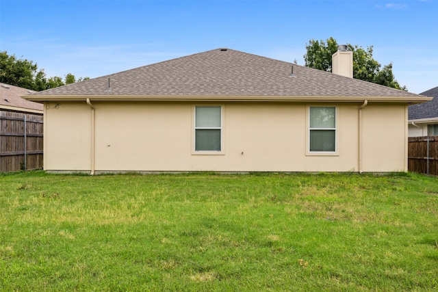 rear view of property with a yard