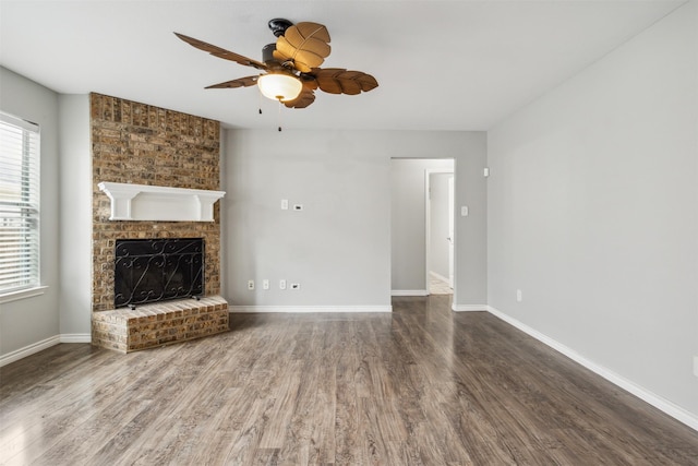 unfurnished living room with a brick fireplace, hardwood / wood-style floors, and ceiling fan