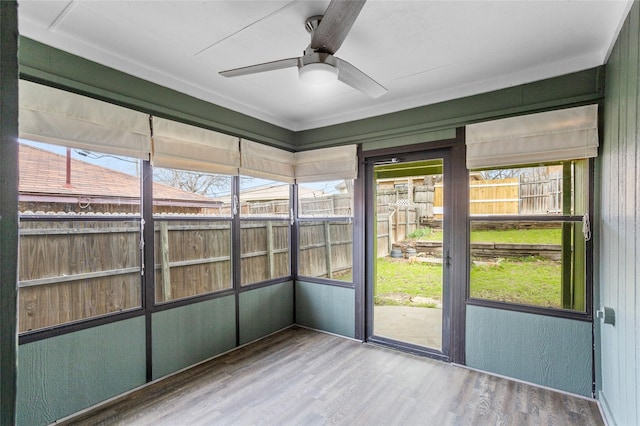 unfurnished sunroom with ceiling fan and plenty of natural light