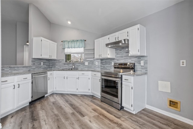 kitchen featuring appliances with stainless steel finishes, white cabinetry, lofted ceiling, light stone countertops, and light wood-type flooring