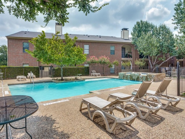 view of swimming pool with a patio, a hot tub, and pool water feature