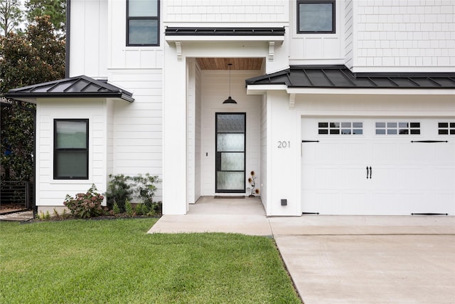 view of exterior entry with a garage and a yard