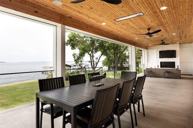 view of patio / terrace featuring an outdoor fireplace, a water view, and ceiling fan