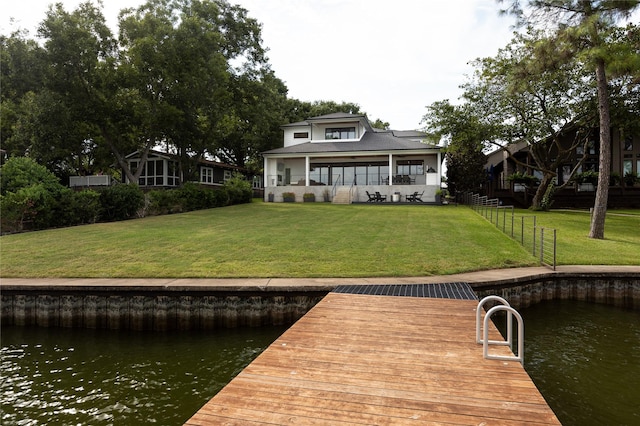 view of dock featuring a water view and a yard