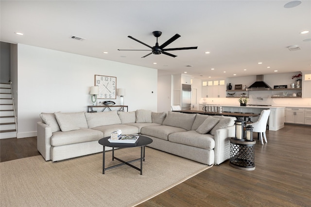 living room with dark hardwood / wood-style flooring and ceiling fan