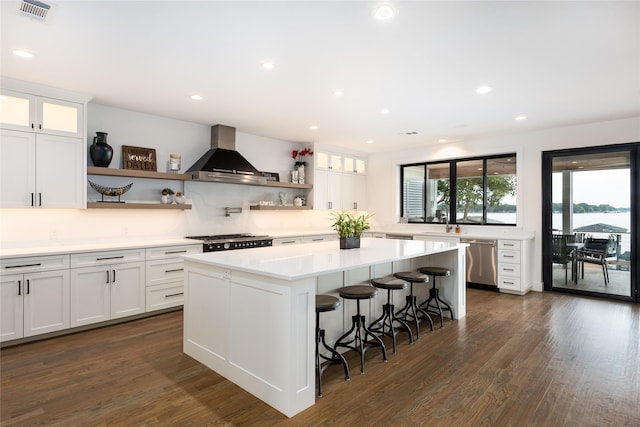 kitchen featuring white cabinetry, wall chimney exhaust hood, and dishwasher