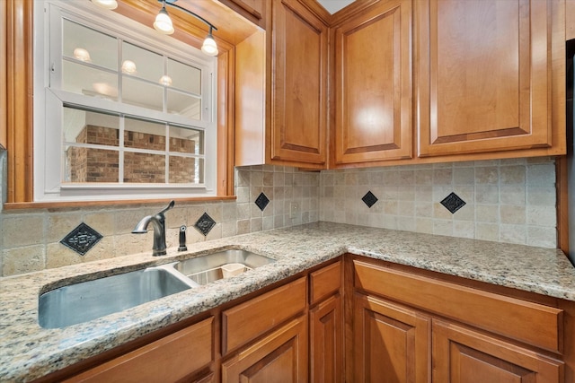 kitchen with sink, backsplash, and light stone countertops