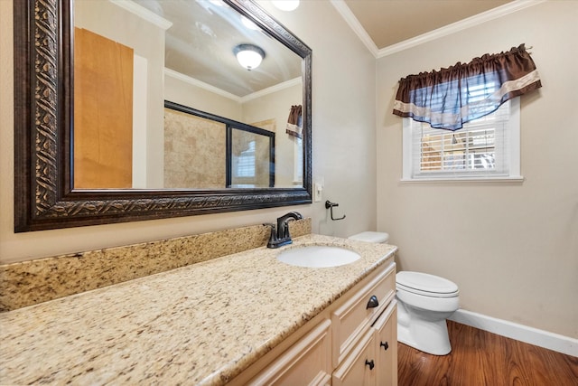 bathroom featuring crown molding, hardwood / wood-style floors, vanity, toilet, and walk in shower