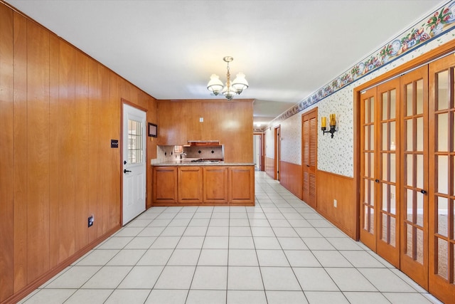 kitchen featuring an inviting chandelier, light tile patterned floors, pendant lighting, and kitchen peninsula