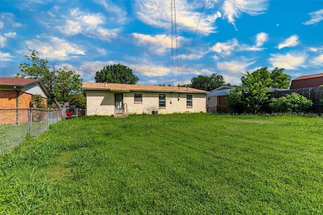 rear view of property featuring a lawn