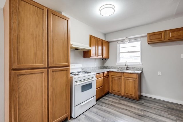 kitchen featuring sink, light hardwood / wood-style flooring, and white gas stove