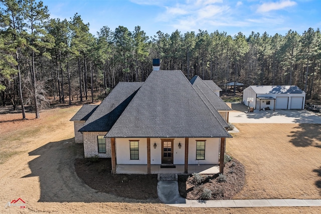 view of front of property featuring a garage, an outbuilding, and covered porch