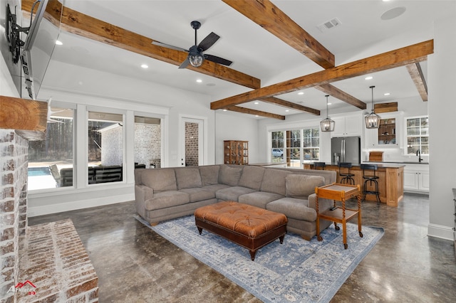 living room featuring beamed ceiling, sink, and ceiling fan