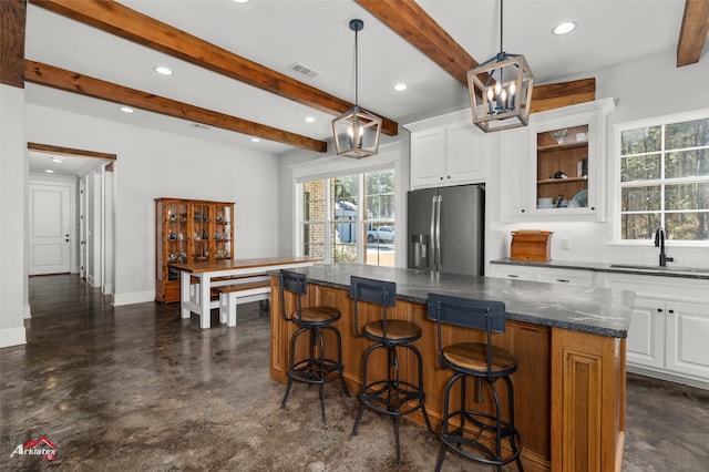 kitchen with white cabinetry, pendant lighting, a kitchen island, and stainless steel refrigerator with ice dispenser