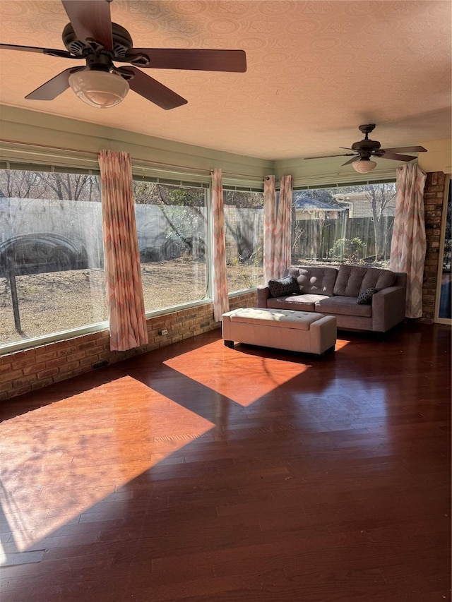 unfurnished sunroom featuring a wealth of natural light and ceiling fan