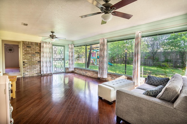 1225 Crestwood Dr, Cleburne, TX 76033 - interior space featuring brick wall, a textured ceiling, visible vents, hardwood / wood-style floors, and ceiling fan