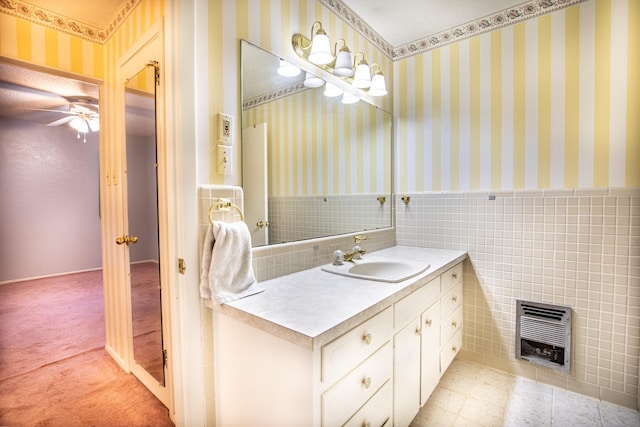 1225 Crestwood Dr, Cleburne, TX 76033 - bathroom with vanity, a ceiling fan, a wainscoted wall, tile walls, and heating unit