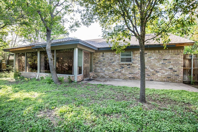 1225 Crestwood Dr, Cleburne, TX 76033 - rear view of house featuring a sunroom, a patio, fence, and brick siding