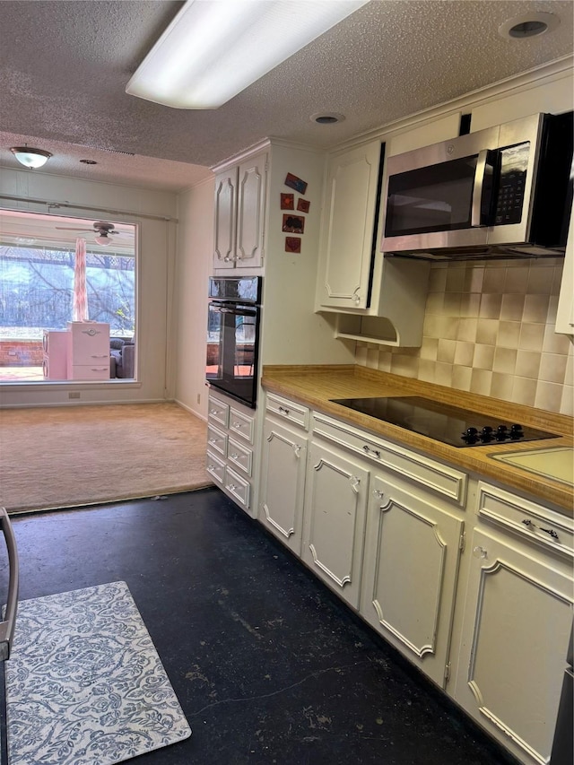 kitchen with tasteful backsplash, white cabinetry, a textured ceiling, and black appliances