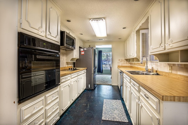 1225 Crestwood Dr, Cleburne, TX 76033 - kitchen with a sink, wooden counters, black appliances, and decorative backsplash