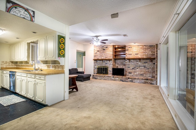 1225 Crestwood Dr, Cleburne, TX 76033 - kitchen with brick wall, a textured ceiling, a brick fireplace, ceiling fan, and carpet