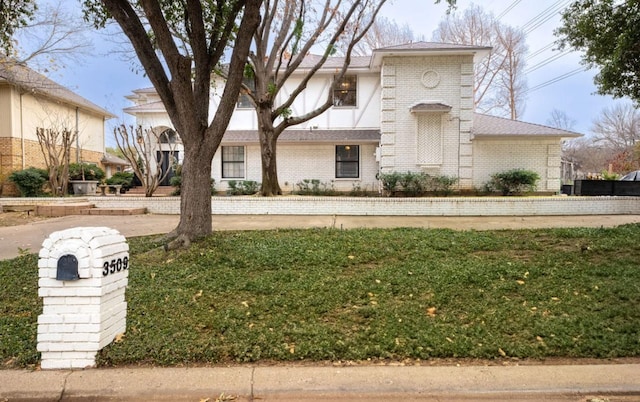 view of front of home with a front lawn and brick siding