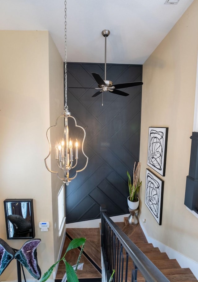 room details featuring ceiling fan with notable chandelier and baseboards