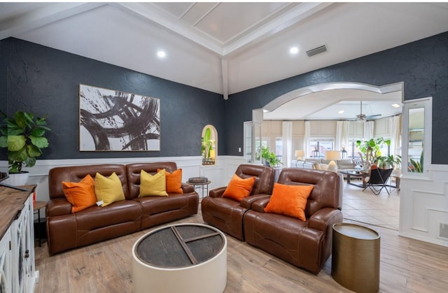 cinema room featuring beamed ceiling, ceiling fan, and light wood-type flooring