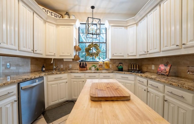 kitchen featuring hanging light fixtures, decorative backsplash, stainless steel dishwasher, white cabinets, and a sink