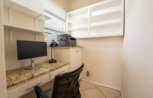 office with baseboards, light tile patterned flooring, and built in study area