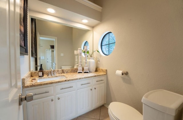 half bathroom with recessed lighting, a textured wall, toilet, vanity, and tile patterned flooring