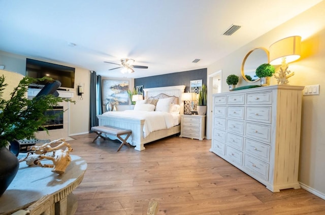 bedroom with ceiling fan, baseboards, visible vents, and light wood-style floors