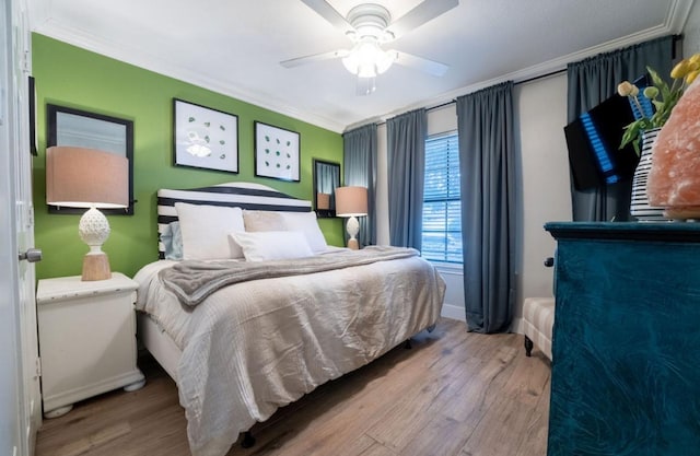 bedroom with crown molding, ceiling fan, and wood-type flooring