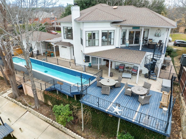 view of swimming pool featuring a fenced in pool, stairway, outdoor dining space, fence, and a wooden deck