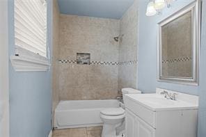 full bathroom featuring vanity, tiled shower / bath, tile patterned floors, and toilet