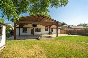 rear view of property featuring a yard and a patio area