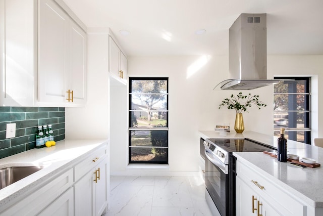 kitchen featuring white cabinetry, island exhaust hood, light stone countertops, and stainless steel range with electric stovetop