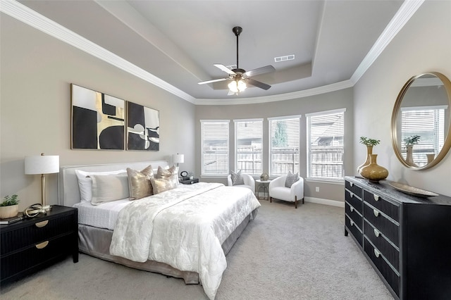 bedroom featuring a tray ceiling, ornamental molding, light colored carpet, and ceiling fan