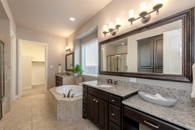 bathroom featuring shower with separate bathtub, vanity, and tile patterned floors