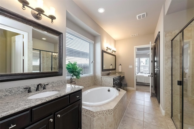 bathroom with independent shower and bath, vanity, a healthy amount of sunlight, and tile patterned floors