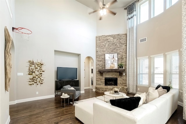 living room featuring a fireplace, a wealth of natural light, dark wood-type flooring, and ceiling fan