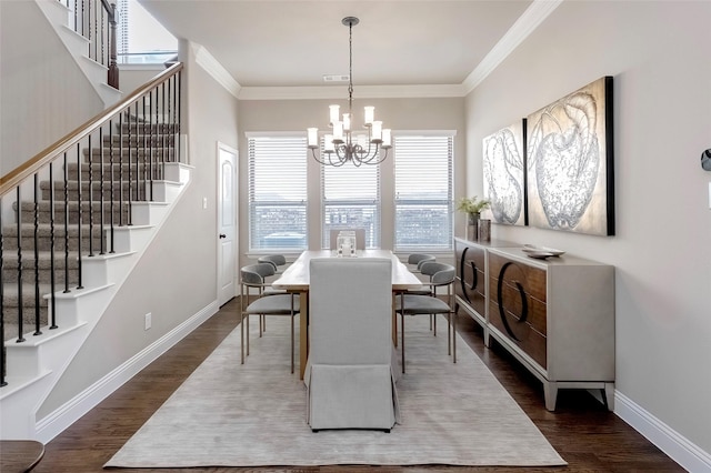 dining space featuring dark wood-type flooring, crown molding, and a chandelier