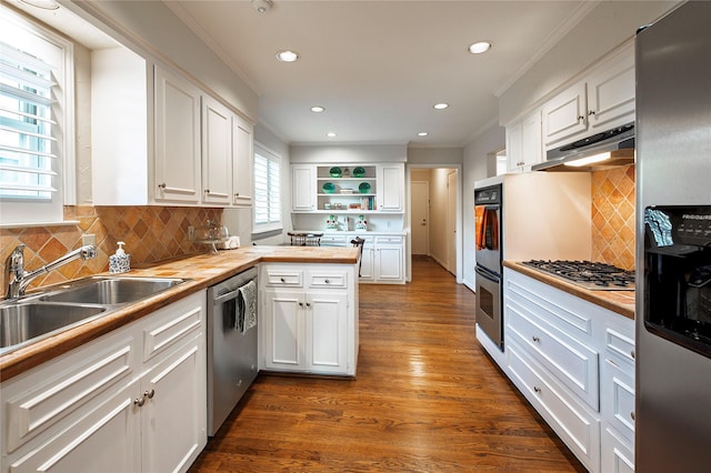 kitchen with stainless steel appliances, white cabinetry, butcher block counters, and crown molding