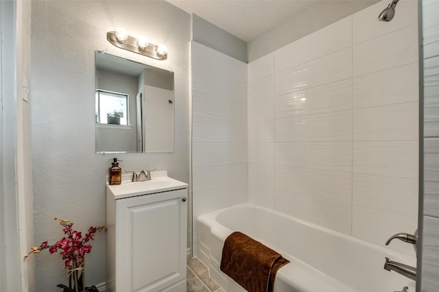 bathroom featuring tiled shower / bath and vanity