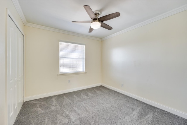 carpeted spare room featuring crown molding and ceiling fan