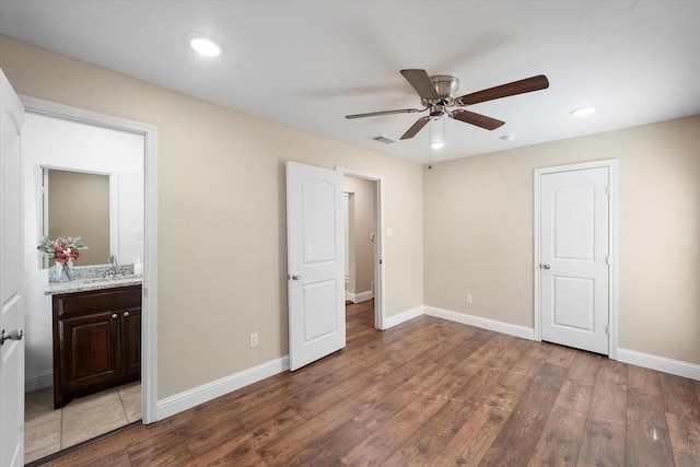 unfurnished bedroom with hardwood / wood-style flooring, ceiling fan, and ensuite bathroom